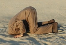 business man with his head buried in the sand